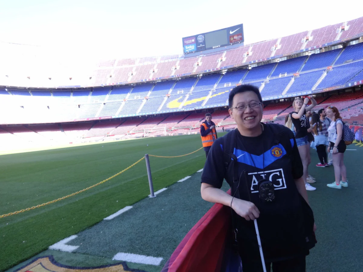 2016年，Alex到西班牙公幹， 到巴塞的魯營球場參觀，堅 持穿著曼聯的波衫。