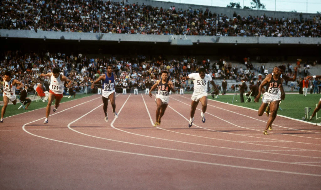 American champion Jim Hines (R) crosses victoriously the finish line of the Olympics men's 100m final, clocking a time of 9.9, 14 October 1968 in Mexico City. From L to R : Madagascan Jean-Louis Ravelomanantsoa, Canadian Harry Jerome, French Roger Bambuck (5th), U.S Mel Pender (6th), Jamaican Lennox Miller (2nd-silver), U.S Jim Hines (1st-gold). Hines was the first man who ran the 100m under 10" with a time of 9,95, world record that he retained for 15 years. He won also the gold of the 1968 Mexico Olympics 4x100m event. (Photo by EPU / AFP)