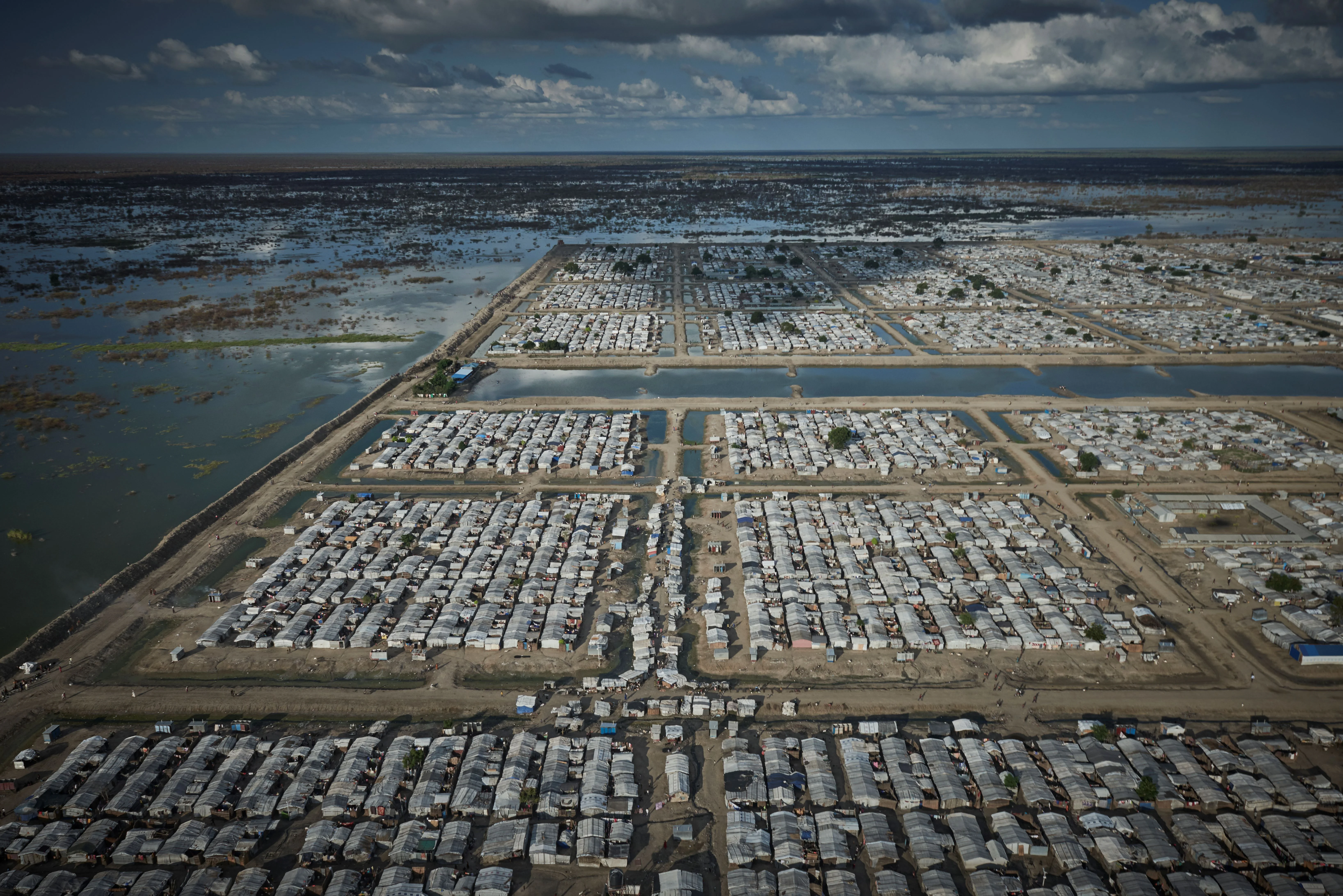 本提烏（ Bentiu ）的流離失所者營地四面臨水，實際上是個被堤壩保護的島，而且營地缺乏基礎設施、狹小和擠迫，居民生活困苦。＠無國界醫生圖片