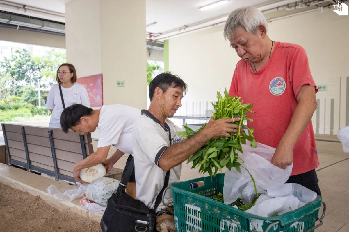 楊仔（右二）協助街坊義工分裝通菜