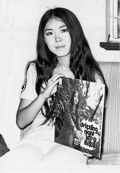 關菊英十四歲開始登台唱歌，圖中她手持自己的國語唱片《今夜雨濛濛》。