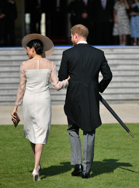 Britain's Prince Harry, Duke of Sussex (R), and his new wife, Britain's Meghan, Duchess of Sussex, attend the Prince of Wales's 70th Birthday Garden Party at Buckingham Palace in London on May 22, 2018. The Prince of Wales and The Duchess of Cornwall hosted a Garden Party to celebrate the work of The Prince's Charities in the year of Prince Charles's 70th Birthday. / AFP PHOTO / POOL / Dominic Lipinski