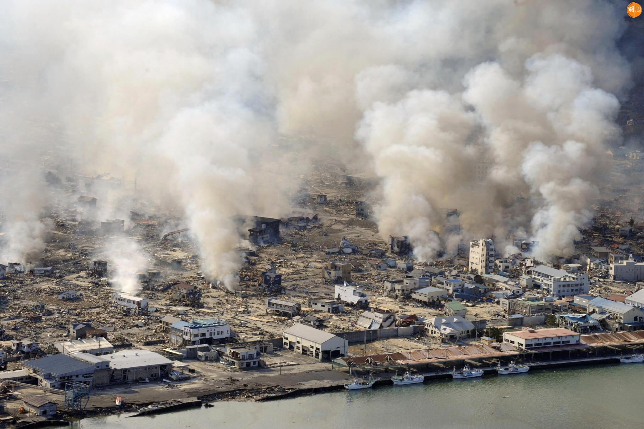 White smokes rises into the air in the badly damaged town of Yamada in Iwate prefecture on March 12, 2011 a day after a massive 8.9 magnitude quake and tsunami hit the region. An explosion at a Japanese nuclear plant triggered fears of a meltdown on March 12, after the massive earthquake and tsunami left more than 1,000 dead and at least 10,000 unaccounted for. JAPAN OUT RESTRICTED TO EDITORIAL USE AFP PHOTO /YOMIURI SHIMBUN (Photo by YOMIURI SHIMBUN / YOMIURI SHIMBUN / AFP)